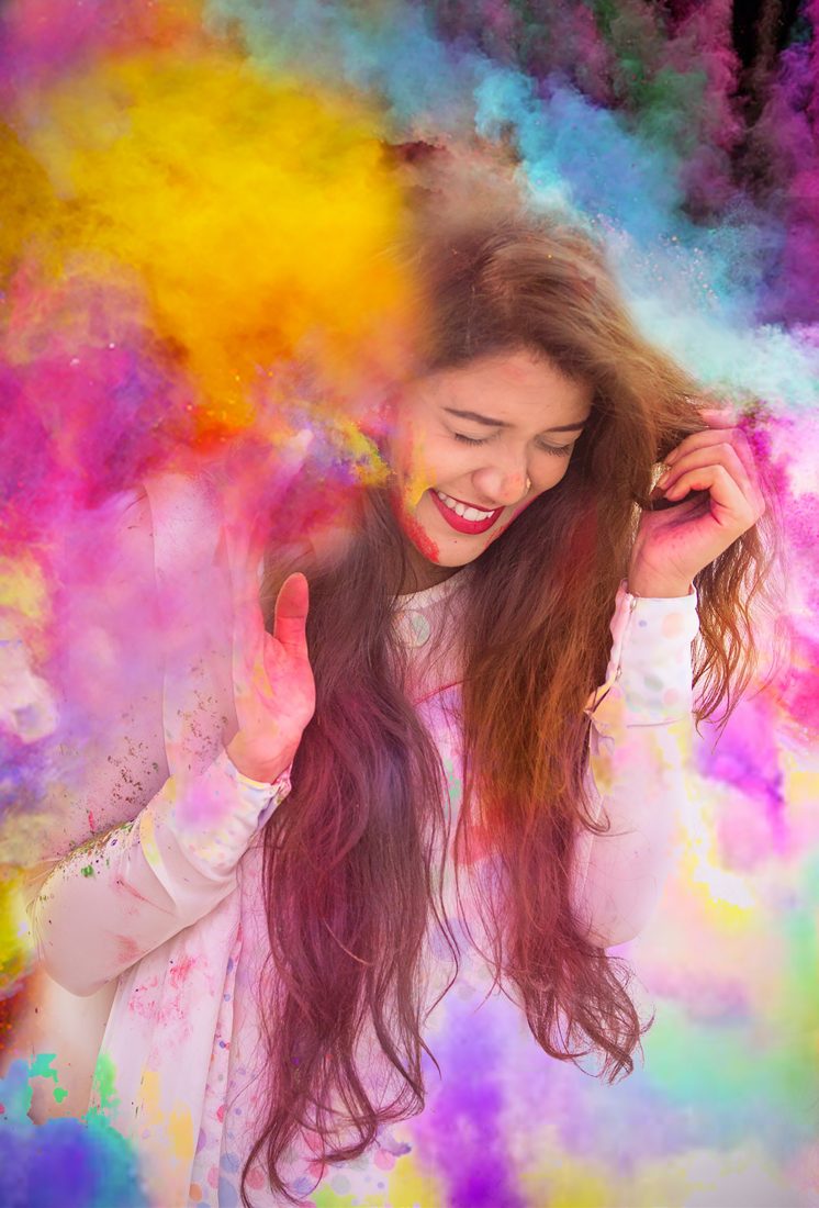 Woman laughing in colored powder