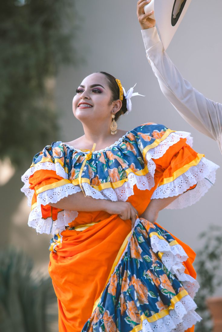 Folk dancer in an orange and blue dress